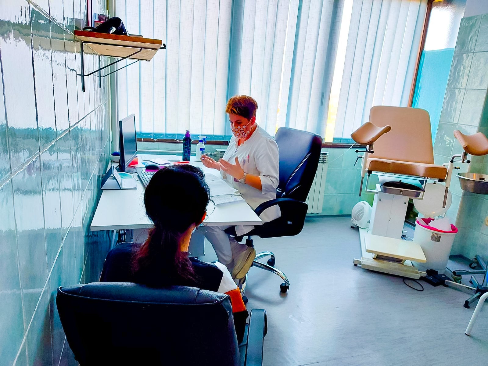 Young girl sitting as gynaecologist talks