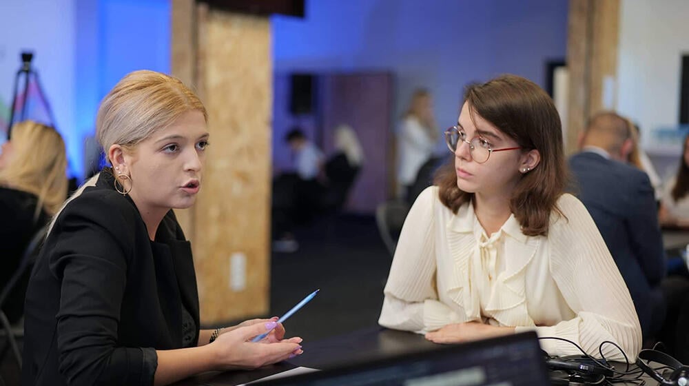 two young women sitting and talking