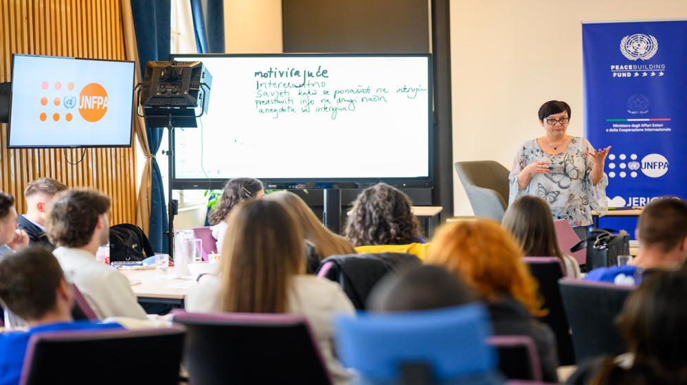 Grupa studenata na radionici sluša predavačicu koja govori o strategijama za izgradnju mira i društveno angažovanje,